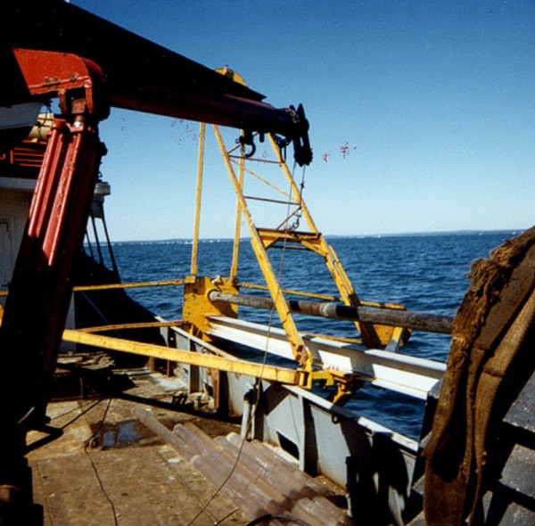 Vibracorer in horizontal position prior to deployment.  Once deployed the vibrating head rides down the aluminum I beam, and the core is taken through the hole in the base plate to the left. Pictures below show the core cutter protruding through the base plate.        