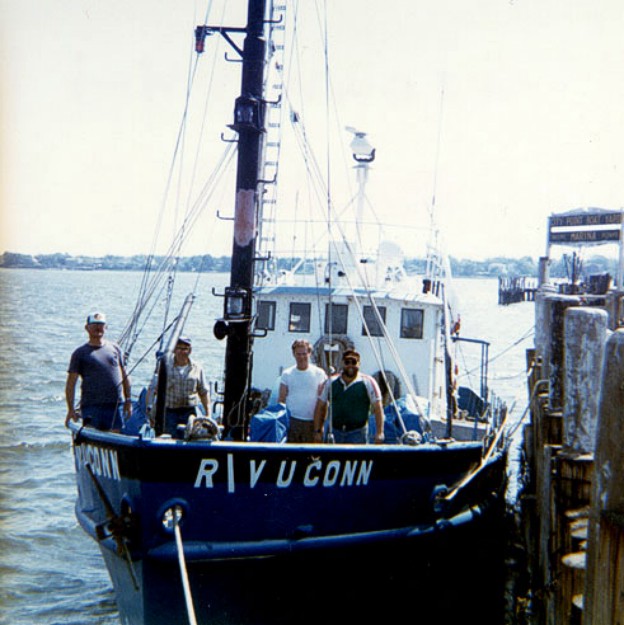 RV UCONN at the dock at City Point Marina, New Haven, CT during cruise UCONN 84-1.  From right to left Dave Nichols (USGS), Captain Larry Burch (University of Connecticut, UCONN), "Red" Banker (UCONN) and Dave Mason (USGS) pose for posterity.