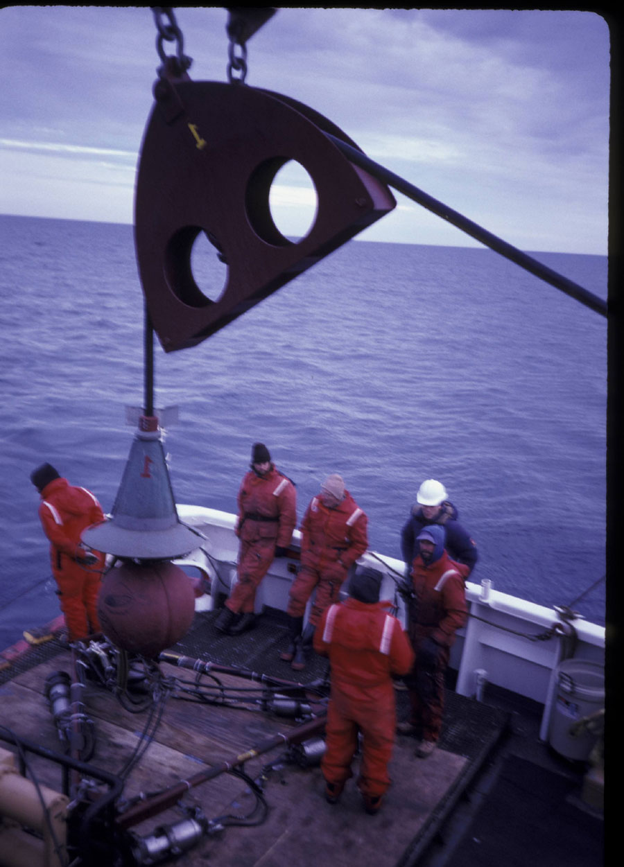 Photograph of the seismic system on deck, showing the air guns and frame, the towing weight, and the conical steel trumpet that protected the wet end connection point - Full Size