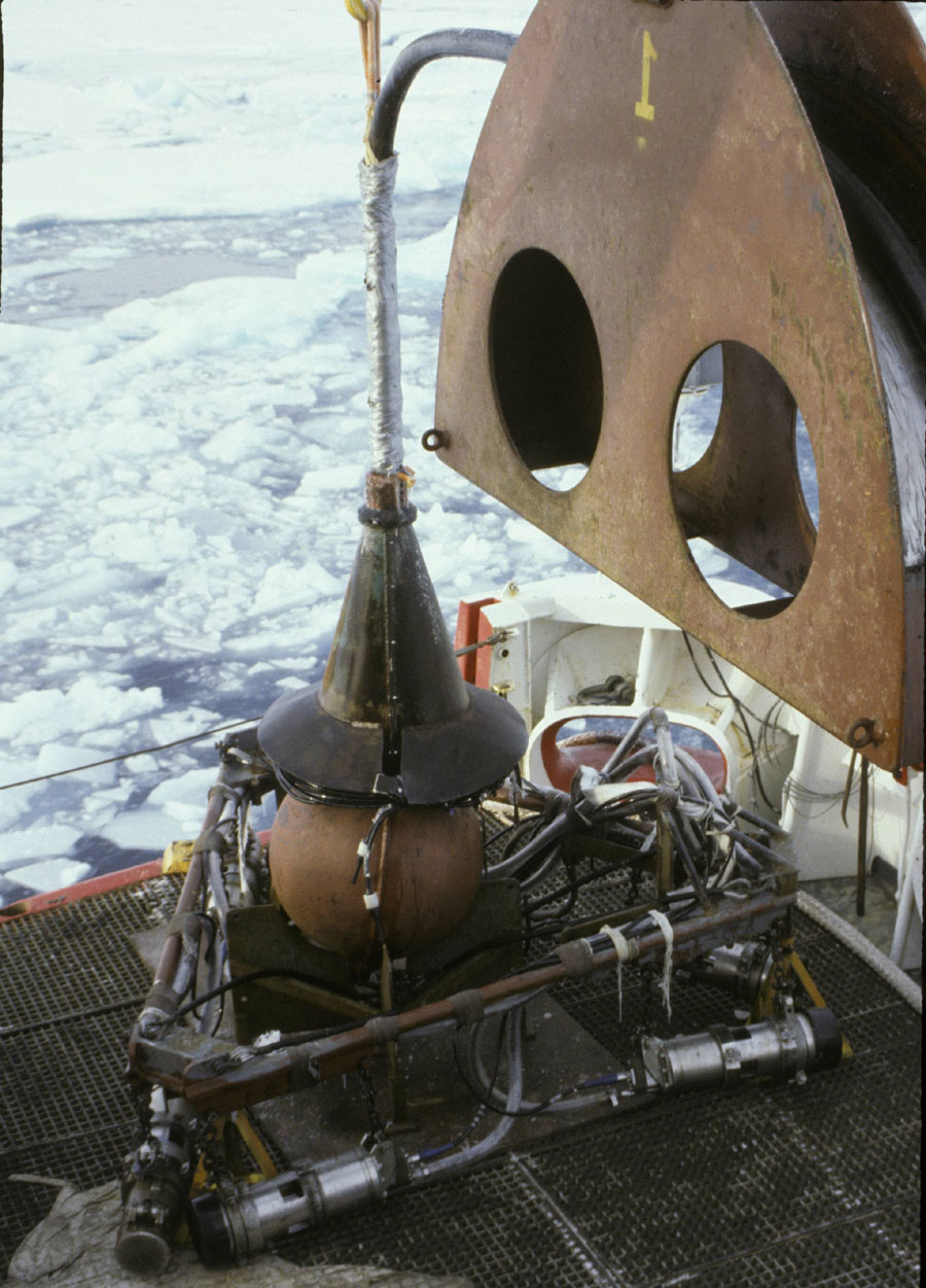 Photograph of the seismic system on deck, showing the air guns and frame, the towing weight, and the conical steel trumpet that protected the wet end connection point - Full Size