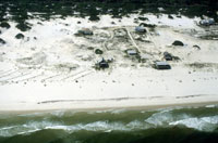 Photo showing beach and a few small houses.