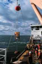 Figure 5A. Subsurface mooring that includes a 36  inch steel float  with temperature-salinity sensor attached, a time-series sediment trap  being deployed from U.S. Coast Guard Cutter Marcus Hannah in Massachusetts Bay.   