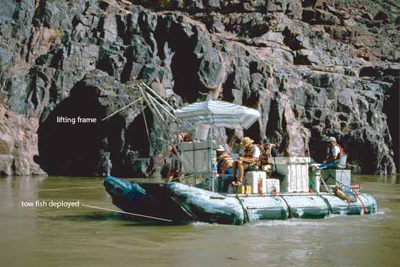 photo of a rubber raft loaded with equipment floating down the gorge