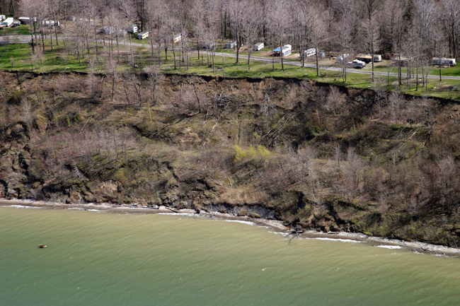 Figure 10. Photograph showing area of classic translational slope failure along coast of Lake Erie, Pa., where a relatively linear mass of bluff material separates and slides downslope. This type of slope failure is most common in bluffs composed of sand and silt. Photographs from Pennsylvania Coastal Resource Management Program.