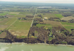 Figure 5. Oblique aerial photograph looking south from Lake Erie, Pa. The division between the Central Lowland Province and the Appalachian Plateau Provinces is demarcated by the dark tree line near the top of the photo (indicated by white line). Photograph from Pennsylvania Coastal Resource Management Program.