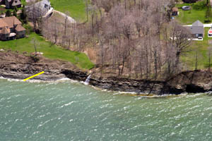 Figure 6. Oblique aerial photograph of bluffs in Harborcreek Township, Pa. (see fig. 3 for location). The base of the bluff in this location is exposed Devonian sandstone and shale, which is overlain by unconsolidated glacial deposits (contact indicated by yellow line). Bluff recession rates tend to be lower where the basal exposures are bedrock. Photograph from Pennsylvania Coastal Resource Management Program.