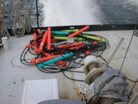 Thumbnail image for Figure 2, photograph of CRP streamer coiled on the deck of the survey vessel during transit, and link to larger image.