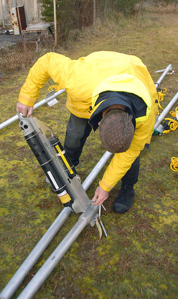 Figure 2, A USGS employee mounting a cantilever arm holding an Aquadopp and pinger onto a jet pipe.  Photo courtesy of Don. 