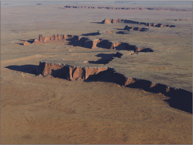 5.	The Moenave Formation crops out along the lower part of the Garces Mesas, northeastern
                              Arizona. The silicified sandstone of the Kayenta Formation is visible as white caprock
                              at the top of the Garces Mesas.
