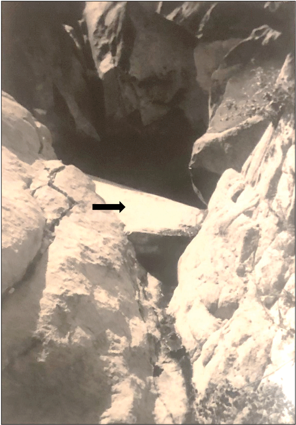 2.2. An opening within rock with a concrete wall on one side.