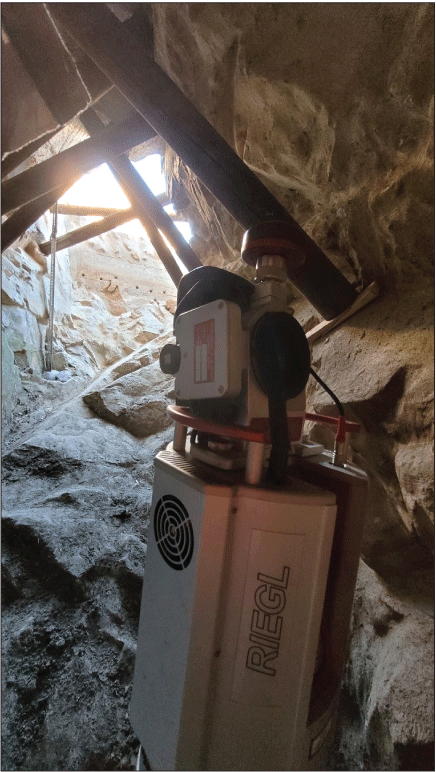 2.17. Scientific instument in a rocky tank with wooden beams above.