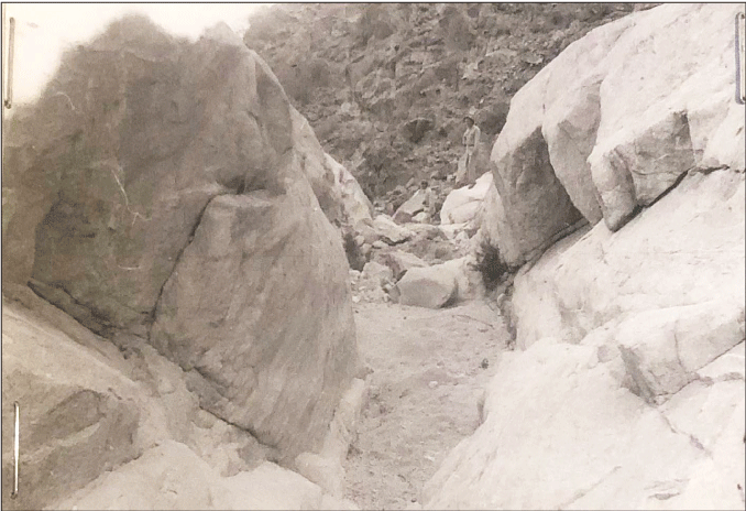 2.27. A narrow channel bounded by rock with sediment in the foreground and cobbles
                  in the background.