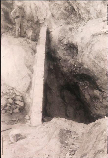 2.30. Person stands upstream of a concrete wall. The downstream side appears to have
                  a lower channel bed.