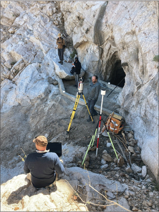 2.33. Surveyors and equipment at entrance to tank. Tank entrance is preceded by a
                  short catchment wall.