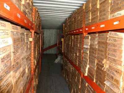 Boxes are stacked bottom to top, front to back of container in adjacent stacks; a
                     walkway width of space is between them.