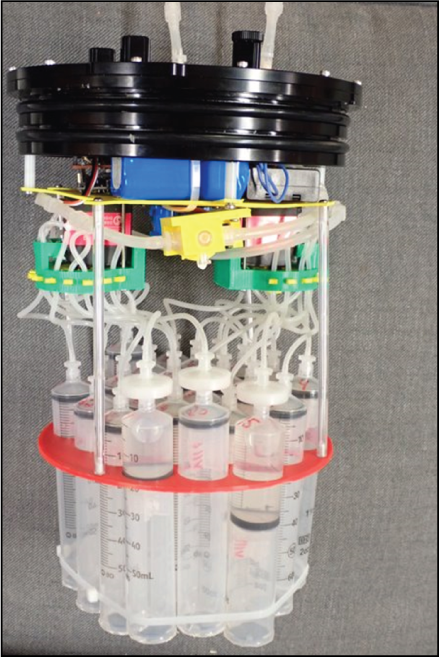 Bundle of clear syringes connected to filter discs and tubes at top; electronic components
and connections at the top.