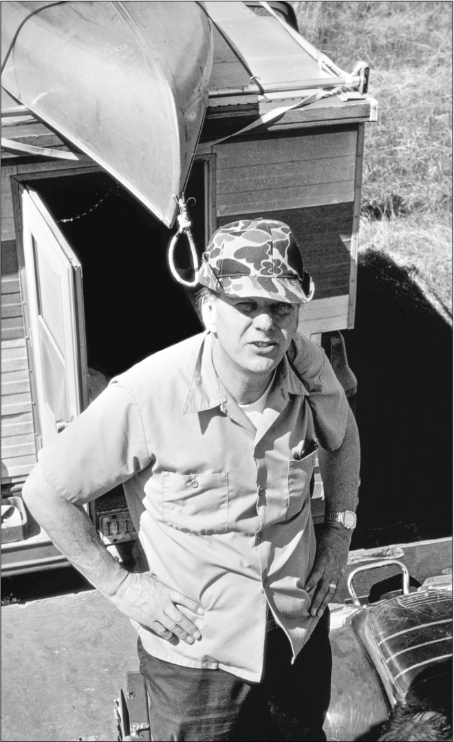 Man looking up at camera with camper truck in background.