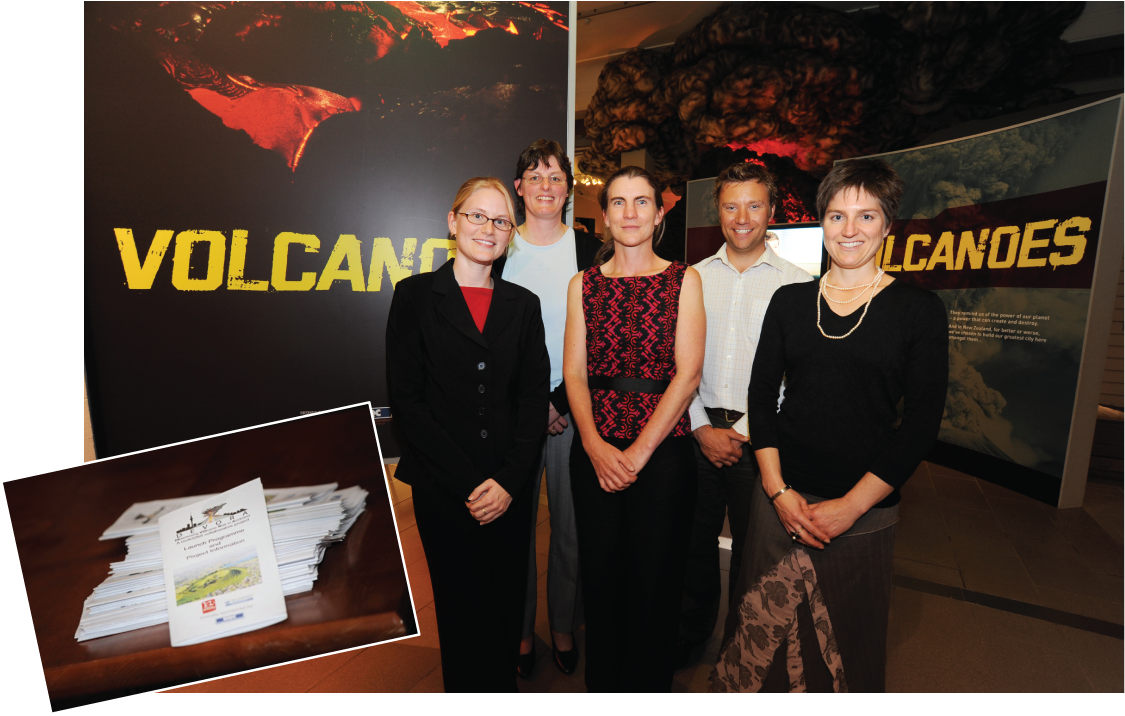 Alttext 2: Five smiling people standing in front of the volcanoes exhibit at Auckland
                     Museum and looking toward the camera.