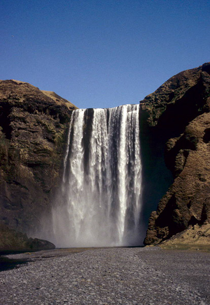 Figure 2-2.–Ground photograph of glacial meltwater plunging over the 60-m-high Skógafoss waterfall, southern Iceland. The glacial meltwater originates from the Eyjafjallajökull ice cap and flowssouth into the North Atlantic Ocean. Photograph by Richard S. Williams, Jr., U.S. Geological Survey.