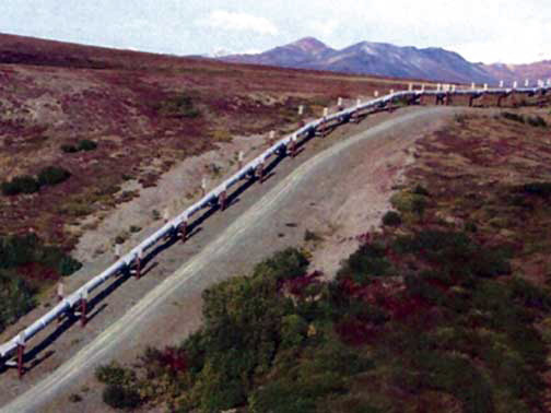 Figure 6-4.–Ground photograph of the Trans-Alaska Pipeline and parallel access road constructed on ice-rich permafrost. The pipeline is constructed on elevated thermopiles to dissipate heat and prevent thawing of permafrost.
