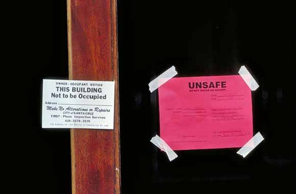 Photo of signs taped to front of building that read 'Unsafe' and 'this building not be be occupied'