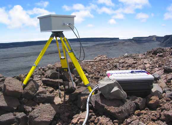 photo of camera in protective box mounted on tripod and aimed down into a crater.
