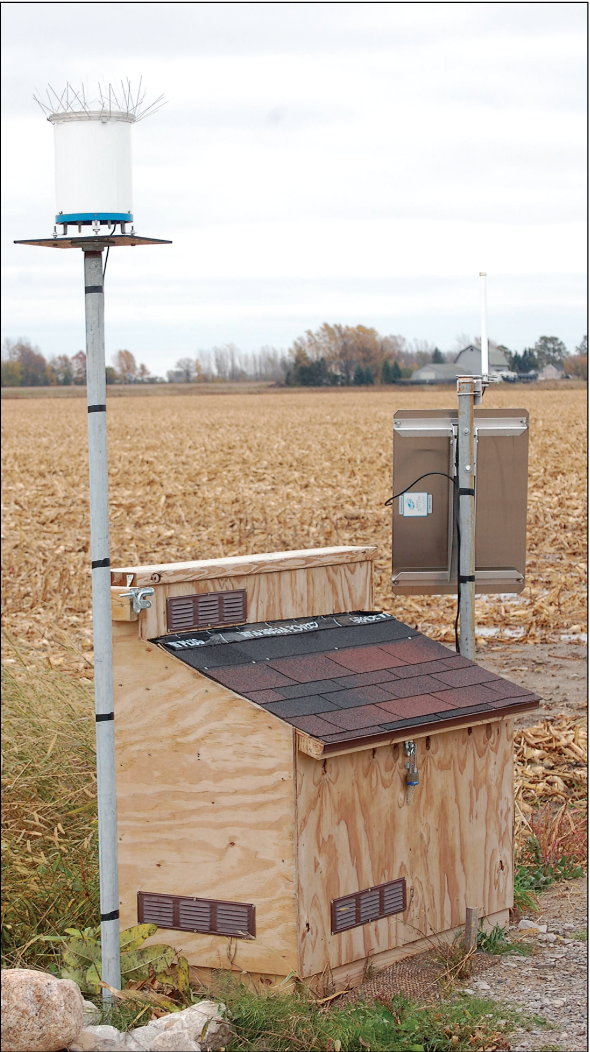 Figure 5.	Equipment enclosure and tipping bucket rain gage at the runoff site in the
                           surface-water study area.