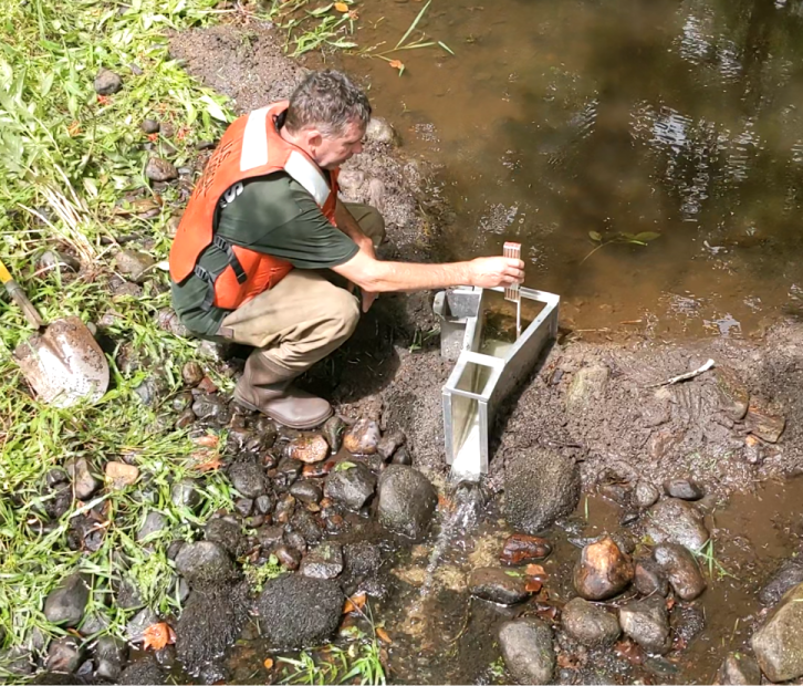 Scientist uses a tool to measure low streamflow