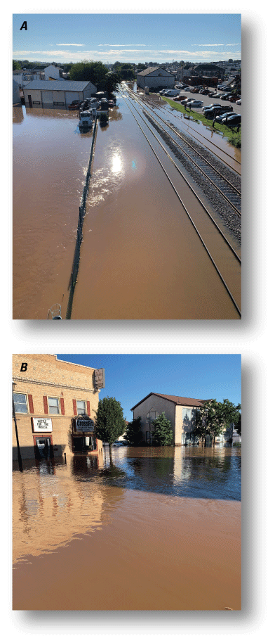 Figure 1. In first photograph, flood waters surround a building, vehicles, and railroad
                     tracks and in second photograph, the lower levels of buildings are submersed in floodwater.