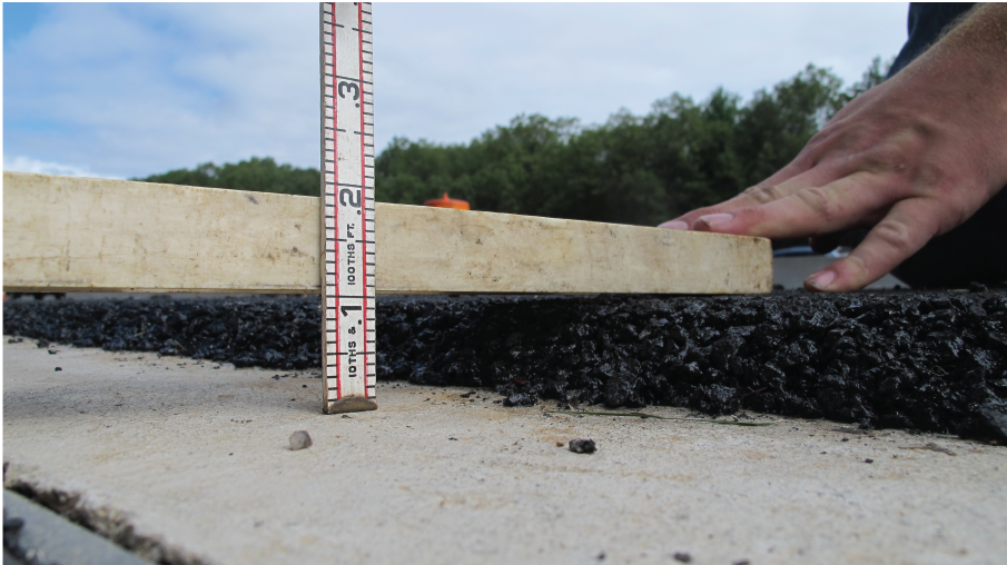 The thickness of the open-graded friction course pavement layer is measured with a
                     ruler that shows tenths and hundredths of a foot. 