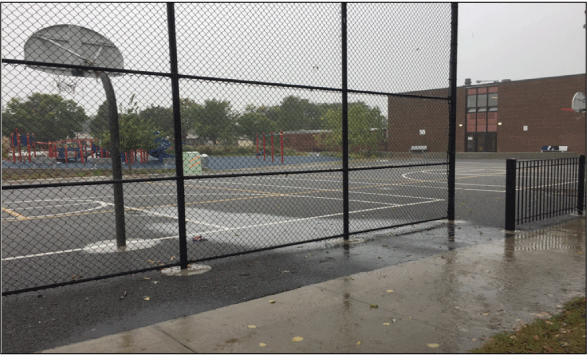 Water flowing from the street to the playground permeable pavement.