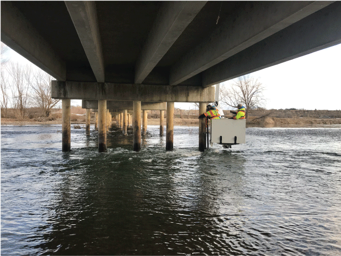 Photograph showing U.S. Geological Survey (USGS) and Idaho Transportation Department
                           (ITD) personnel installing a sonar device at the upstream pier of bent two at ITD
                           bridge structure 19935 on January 15, 2020. The site is co-located with USGS station
                           Payette River near Letha, Idaho (USGS station number 13250000)