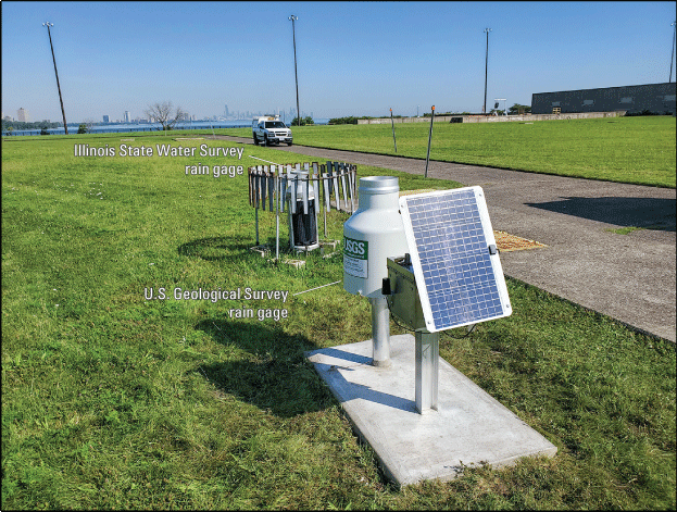 Photograph of the northeast view of the Rain Gage at South Shore, Illinois, with the
                  ISWS gage in the background of USGS gage.
