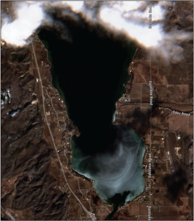 Osoyoos Lake and surrounding land features are shown along with light cloud cover
                  on the lake’s northern edge.