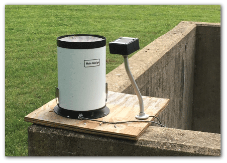 Photo of bucket and rain gage by deployment location.